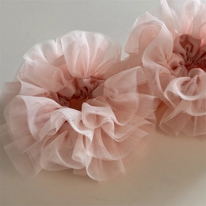 Close-up of pink layered mesh lace scrunchies with soft pleated texture and elastic band