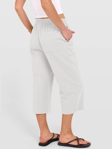Vista posteriore dei pantaloni capri in lino bianco da donna con dettagli tasca e taglio ampio
