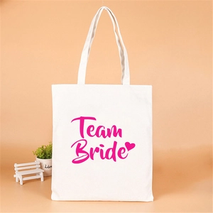 Close-up of white Team Bride canvas tote bag with pink lettering for bachelorette parties