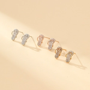 Detailed close-up of flip-flop stud earrings in silver, rose gold, and gold with zircons