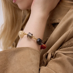Close-up of vintage multi-color resin gemstone bracelet worn with a suede tassel jacket
