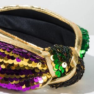 Vue détaillée du serre-tête festif avec paillettes violettes, vertes, dorées et nœud d'or
