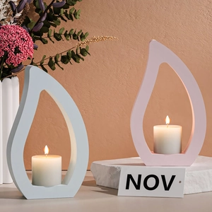 Detalle de portavelas de silicona en forma de gota con velas blancas para decoración