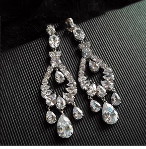 Macro shot of silver drop earrings with pear-cut cubic zirconia on black background