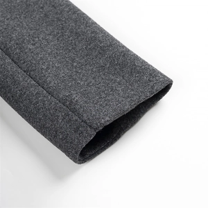 Detailed close-up of dark grey wool coat sleeve showing refined sewing and fabric texture