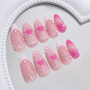 Faux ongles amande rose français avec perles 3D, strass et motifs floraux doux