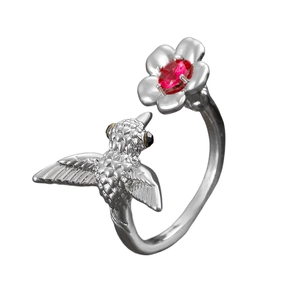 Detail of vintage silver hummingbird ring featuring a red oval stone and floral accents