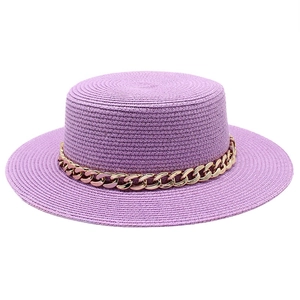 Detailed view of purple straw flat top hat with a chunky gold chain accessory