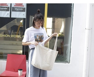 Detail of minimalist cream canvas tote bag showing thick texture and shoulder strap