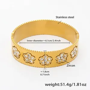 Dettaglio del bracciale rigido dorato in acciaio inossidabile con cinque motivi floreali
