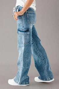 Detail of blue straight-leg denim cargo pants featuring functional side utility pockets