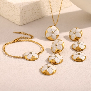 Details von 18K vergoldetem Schmuckset mit weißen Emaille-Blumenanhängern und Diamanten