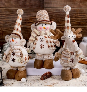 Dettaglio di pupazzi di neve e renne di peluche con sciarpe in maglia per decoro natalizio