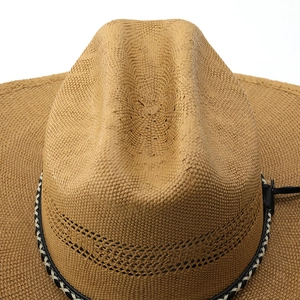 Detail of the woven straw texture and decorative black and white band on a cowboy hat