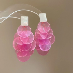 Pink chiffon layered flower tassel earrings with white shell studs on a mirror stand