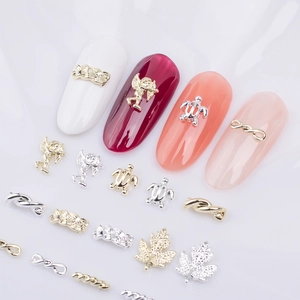 Detailansicht von Nagelschmuck aus Legierung mit Engel-, Schildkröten- und Ahornblatt-Motiven