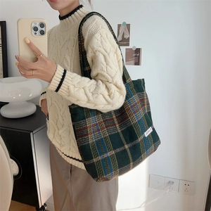 Detailed view of large capacity dark green plaid tweed tote bag styled for autumn