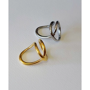Detail view of twisted gold and silver stainless steel rings on white background