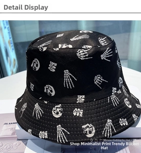 Detail of black cotton bucket hat featuring white skull print and BOO text patterns