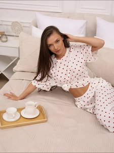 Detail of soft white women's pajama set with red heart print and elastic waistband