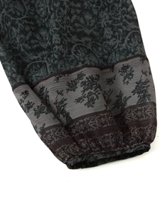 Close-up of metallic print on dark vintage shirt sleeve with elastic cuff detail