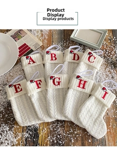Macro detail of white knit Christmas stockings with red embroidered alphabet letters