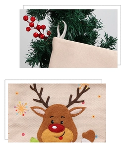 Close-up of linen Christmas stocking with a cartoon reindeer patch and red berry detail