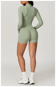 Rear view of mint green high-waist fitness shorts and long-sleeve yoga top on model