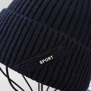 Dettaglio del berretto in maglia a coste blu scuro con etichetta tessuta SPORT
