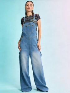Détail de la salopette en jean bleu clair avec poche poitrine et coupe large décontractée