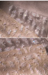 Macro detail of 3D embossed floral and pearl nail stickers with textured white relief