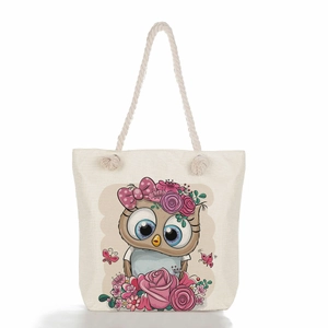 Detail of beige canvas tote with thick rope handles and colorful floral owl print