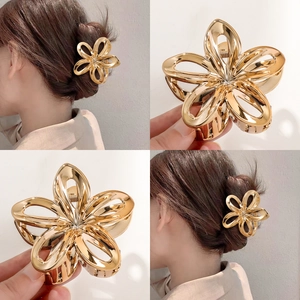 Golden hollow frangipani metal hair claw clip shown in product shots and on a model