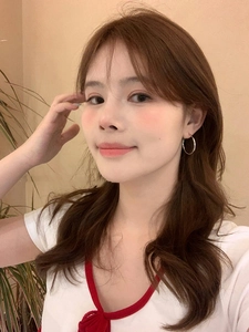 Model wearing minimalist medium-sized silver hoop earrings in a warm indoor setting