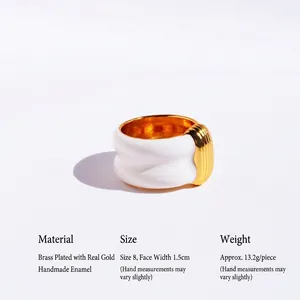 Wide white enamel and gold ribbed textured brass ring shown from a side angle