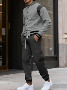 Detail of grey varsity jacket and cargo joggers featuring premium fabric textures