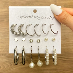 Five-piece silver earring set with butterfly and snake studs displayed on a card