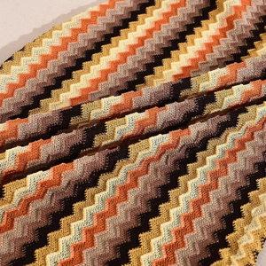Detailed macro view of zig-zag knitted fabric in orange, yellow and black tones
