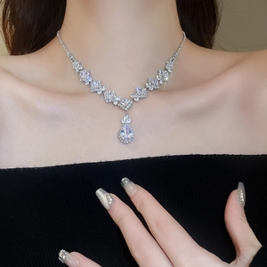 Detailed view of silver water-drop zircon necklace worn by a model in luxury style