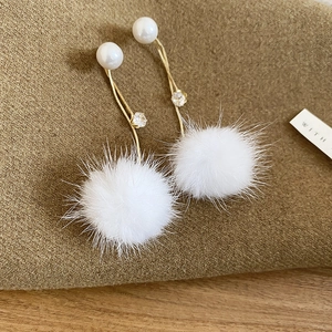 Detailaufnahme von Winter-Ohrhängern mit Plüschpelzkugeln und weißen Perlen