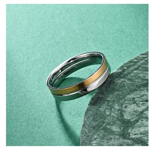 Macro shot of two-tone gold and silver stainless steel ring on green marble stone