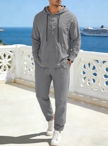 Detail of grey men's linen set showing hooded long sleeve top and pants on a balcony