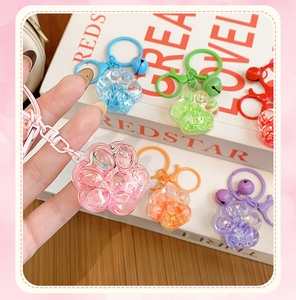 Detailed close-up of colorful cat paw quicksand keychains with floating glitter