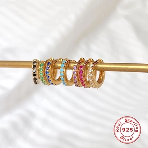 Macro shot of 925 sterling silver huggie earrings with multicolor zircon stones