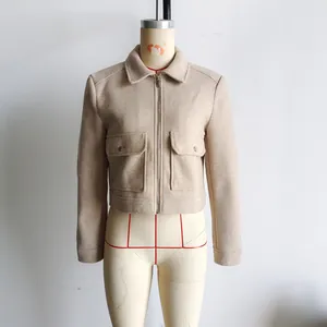Détail d'une veste courte kaki clair en laine avec fermeture éclair et poches poitrine