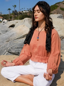 Detail of colorful seven chakra gemstone necklace worn by a model in outdoor setting