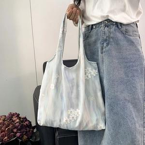 Détail de la broderie florale 3D blanche sur un sac cabas en toile avec dégradé aquarelle