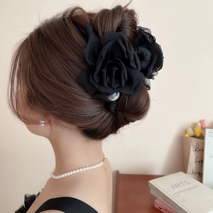 Détail d'une pince à cheveux élégante en résille noire avec perles sur cheveux bruns