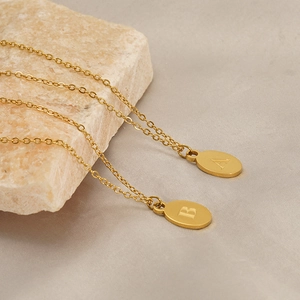 Polished gold stainless steel oval pendants with engraved letters A and B on stone