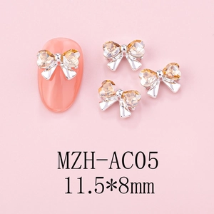 Macro shot of 11.5x8mm bow nail charms with champagne heart crystals on matte pink backdrop